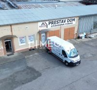 Gebäude in der Fidlikova-Straße in Humenné mit der Aufschrift „Prestav Dom“ und einem Parkplatz.