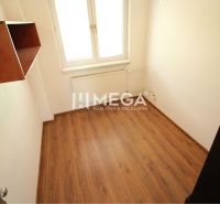 Kleines Büro mit Regal, Boden mit Holzdekor, Fenster und Heizkörper.