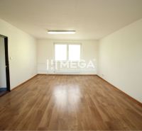 Ein geräumiges Büro mit einem Holzboden und weißen Wänden.