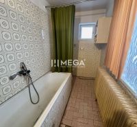 Ein Badezimmer in einem Einfamilienhaus mit einer Badewanne und dekorativen Fliesen.