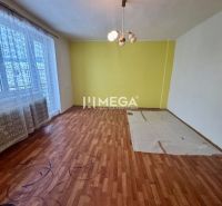 Ein Zimmer mit einem Holzboden und einer gelben Wand in einem Einfamilienhaus.