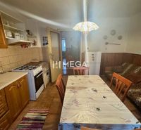 Küche in einem Einfamilienhaus mit Holzdekor, Esstisch, Herd und Kühlschrank.