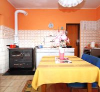 Küche in einem Einfamilienhaus mit orangefarbenen Wänden, Fliesen und Esstisch.