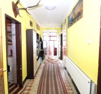 Flur in einem Einfamilienhaus mit Heizkörper, Teppichen und Wanddekorationen.