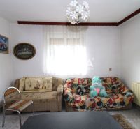 Wohnzimmer in einem Einfamilienhaus mit einem bunten Sofa und dekorativer Beleuchtung.