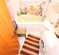 Badezimmer in einem Einfamilienhaus mit grüner Badewanne, Waschmaschine und dekorativen Fliesen.