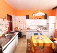Küche in einem Einfamilienhaus mit farbiger Wand, Fliesenverkleidung und Esstisch.
