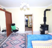 Ein Zimmer in einem Einfamilienhaus mit Teppichen, einem Kamin und Spiegeltüren am Schrank.