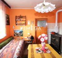 Eine Küche in einem Einfamilienhaus mit orangefarbenen Wänden, einem Herd und Blumendekoration auf dem Tisch.