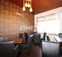 Gasträume mit bequemen Stühlen und einem Boden in Holzoptik.