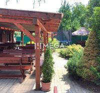 Vranov nad Topľou, Budovateľská: Gastronomische Räumlichkeiten mit Holzsitzgelegenheiten und Grün auf der Terrasse.