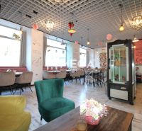 Das Innere eines Cafés mit Holzboden, bequemen Sesseln und Dekorationen an der Decke.