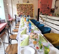 Innenraum von Gastronomiebereichen mit dekorativer Wand und gedecktem Tisch mit bunten Servietten.