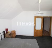 Schlafzimmer im Einfamilienhaus mit Bett, Nachttisch und geflochtenem Korb.