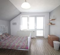 Innenraum eines Einfamilienhauses mit Bett, Schrank und Boden in Holzoptik.