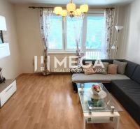 Wohnzimmer in einem Einfamilienhaus mit Sofa, Fernseher und Holzboden.