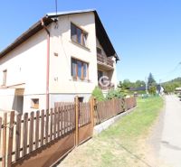 Ein Einfamilienhaus in Nižné Ladičkovce mit Garten, Holzzaun und Asphaltstraße.