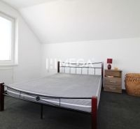 Schlafzimmer in einem Einfamilienhaus mit einem Eisenbett, einem Nachttisch und einem Korb.