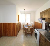 Küche in einem Einfamilienhaus mit Holzverkleidung und Esstisch.