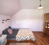 Schlafzimmer in einem Einfamilienhaus mit einem Bett und einem Boden in Holzoptik.