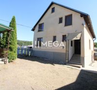 Ein Einfamilienhaus in Nižné Ladičkovce mit Garten und Außenbereich zum Sitzen.