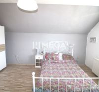 Schlafzimmer in einem Einfamilienhaus mit einem Metallbett, einem Schrank und einem Boden mit Holzdekor.
