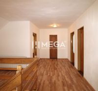 Innenraum eines Einfamilienhauses mit Holzboden und Holzgeländer an der Treppe.