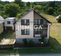 Ein Einfamilienhaus in Nižné Ladičkovce, mit einem Holzzaun und Rasen, umgeben von Grün.