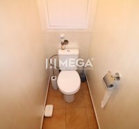 Badezimmer mit Toilette und einfachen Accessoires in einer Vierzimmerwohnung.