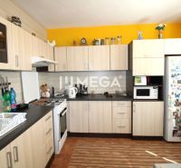 Küche in einer 4-Zimmer-Wohnung mit Holzboden und gelber Wand.