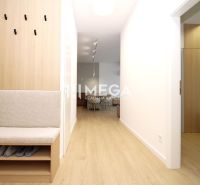 Flur in einer 3-Zimmer-Wohnung mit Holzboden und eingebauter Sitzgelegenheit.