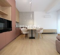 Küche in einer 3-Zimmer-Wohnung mit Tisch, cremefarbenen Stühlen und Boden in Holzoptik.