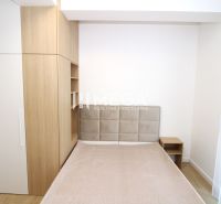 Schlafzimmer in einer 3-Zimmer-Wohnung mit Bett, Einbauschrank und Boden mit Holzdekor.