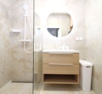 Badezimmer mit Dusche und Holzelementen in einer 3-Zimmer-Wohnung.