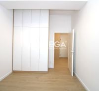 Ein Zimmer in einer 3-Zimmer-Wohnung mit einem weißen Einbauschrank und einem Boden in Holzoptik.