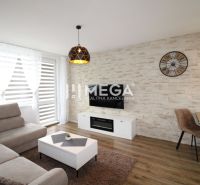 Wohnzimmer mit heller Couch und Boden in Holzoptik in einer 3-Zimmer-Wohnung.