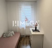Einfaches Interieur einer 3-Zimmer-Wohnung mit Bett und Boden in Holzoptik.