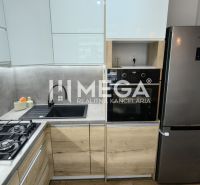 Küche mit weißen Schränken, grauen Fliesen und Geräten in einer 3-Zimmer-Wohnung.