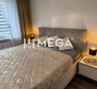 Schlafzimmer in einer 3-Zimmer-Wohnung mit Bett, Nachttischen und Boden mit Holzdekor.