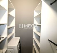 Garderobe in einer 3-Zimmer-Wohnung mit Regalen und Waschmaschine.
