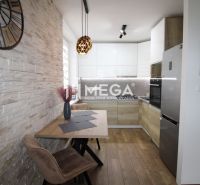 Küche in einer 3-Zimmer-Wohnung mit Holzboden und Steinverkleidung.