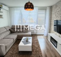 Wohnzimmer in einer 3-Zimmer-Wohnung mit einer Eckcouch und einem Boden in Holzoptik.