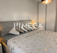 Schlafzimmer in einer 3-Zimmer-Wohnung mit einem bequemen Bett und einer Lampe auf dem Nachttisch.