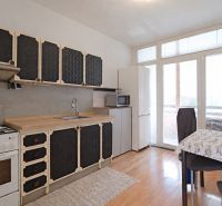 Küche in einer 3-Zimmer-Wohnung mit Holzboden und Essecke.