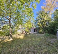 Gärten in der Šípková-Straße in Košice-Krásna mit einer Holzhütte und reicher Vegetation.