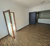Ein Zimmer einer 2-Zimmer-Wohnung mit Holzboden und Glastüren.