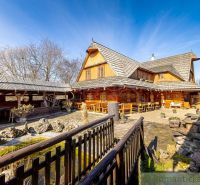 Ein Holzfamilienhaus in Machulince mit Terrasse und Wassermühlrad.