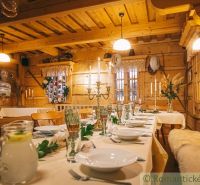 Festlich gedeckter Tisch im Inneren eines Einfamilienhauses mit Holzelementen und Kerzenhaltern.