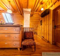 Dachboden eines Einfamilienhauses mit einem Schrank, einem Sessel und einem Boden mit Holzdekor.