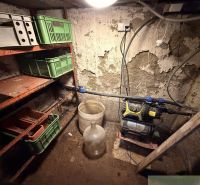 Lagerraum mit Regalen und Plastikboxen in der Hütte.